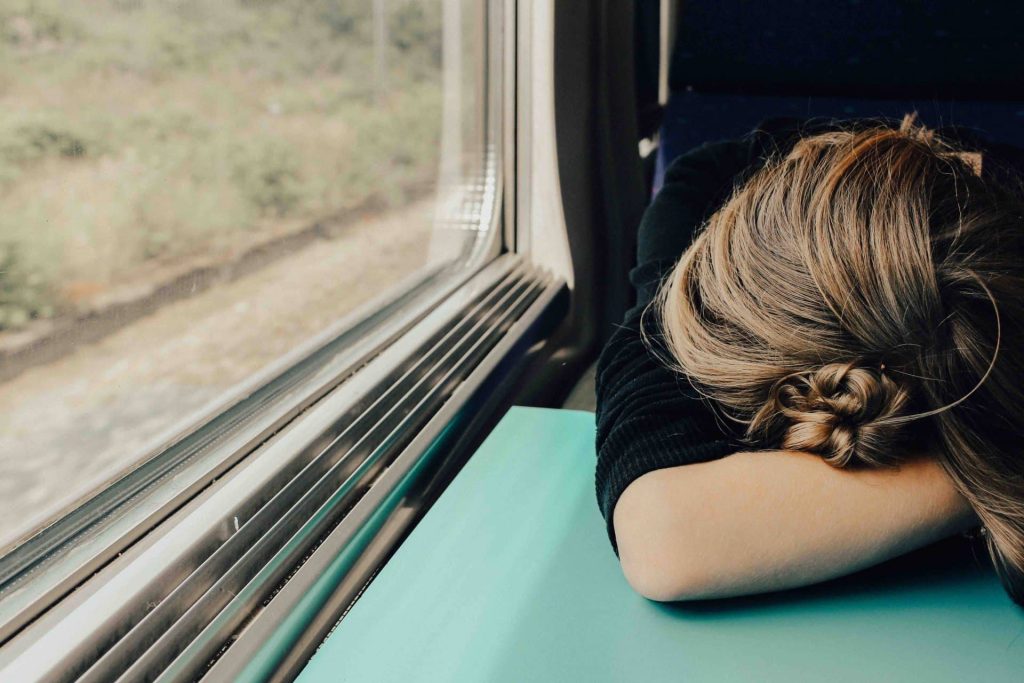 Overspannen, stress. Vrouw die voorovergebogen in de trein zit