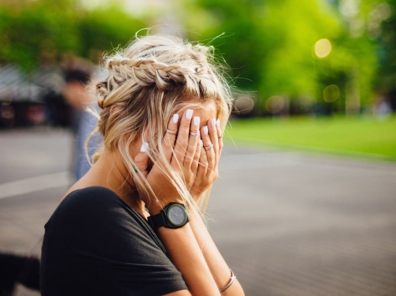 Laag coritsol. Vrouw zit met handen voor gezicht