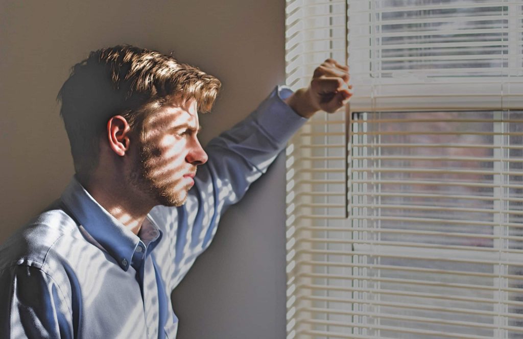 Man met stress staart uit het raam