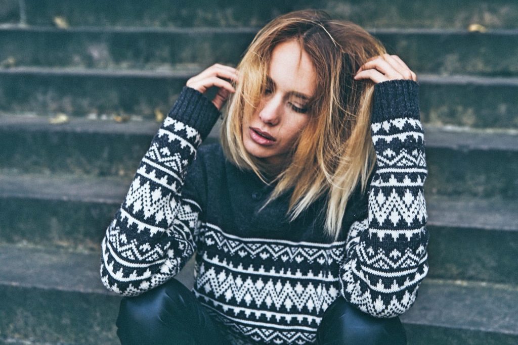Vrouw met hormonale disbalans zit op trap