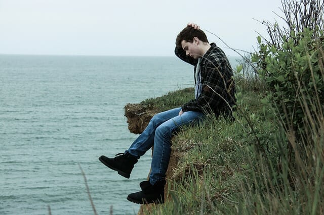 Stress lichaam. Jongen met stressklachten aan zee