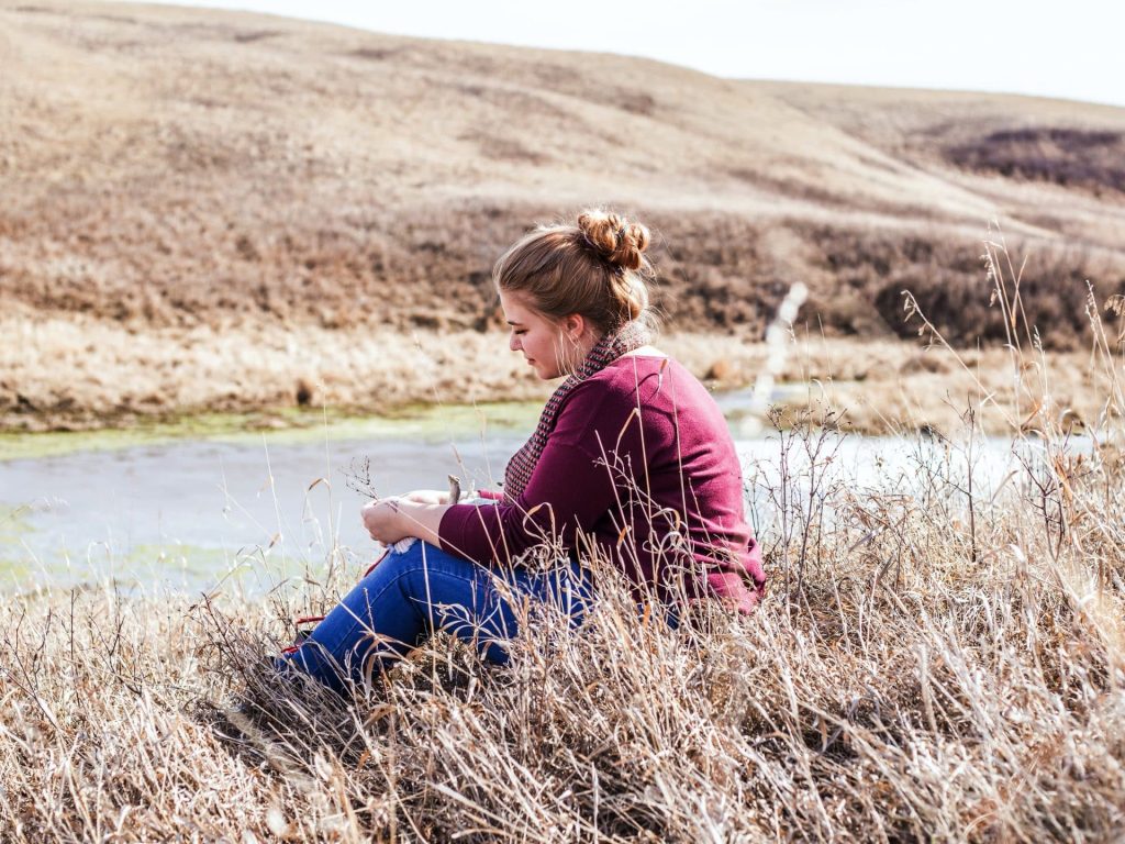 Begeleiding bij burn-out. vrouw zit in duinen