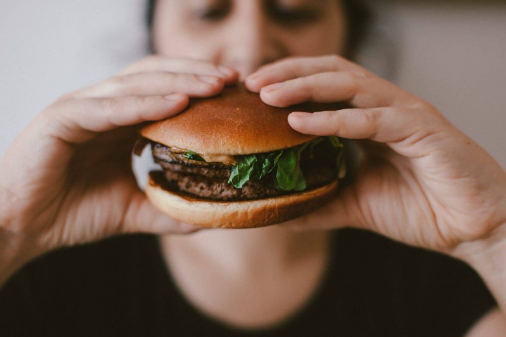 Stress en eten. Gestreste man eet hamburger